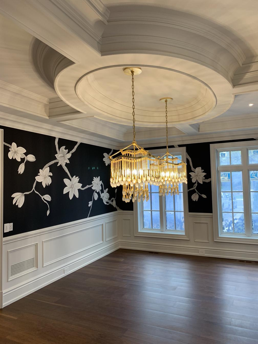 Elegant dining room with classic wood moulding, wall panel trim, and detailed coffered ceiling